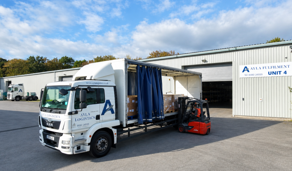 Red forklift loading an Ayla Logistics transport truck outside the Ayla Fulfilment warehouse