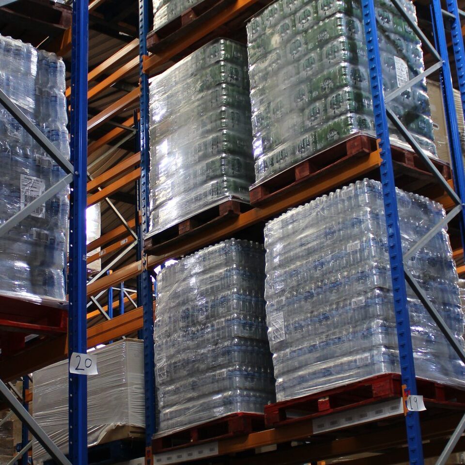 Ayla Group warehouse interior showing pallets of bottled water stored on high industrial racking for UK distribution