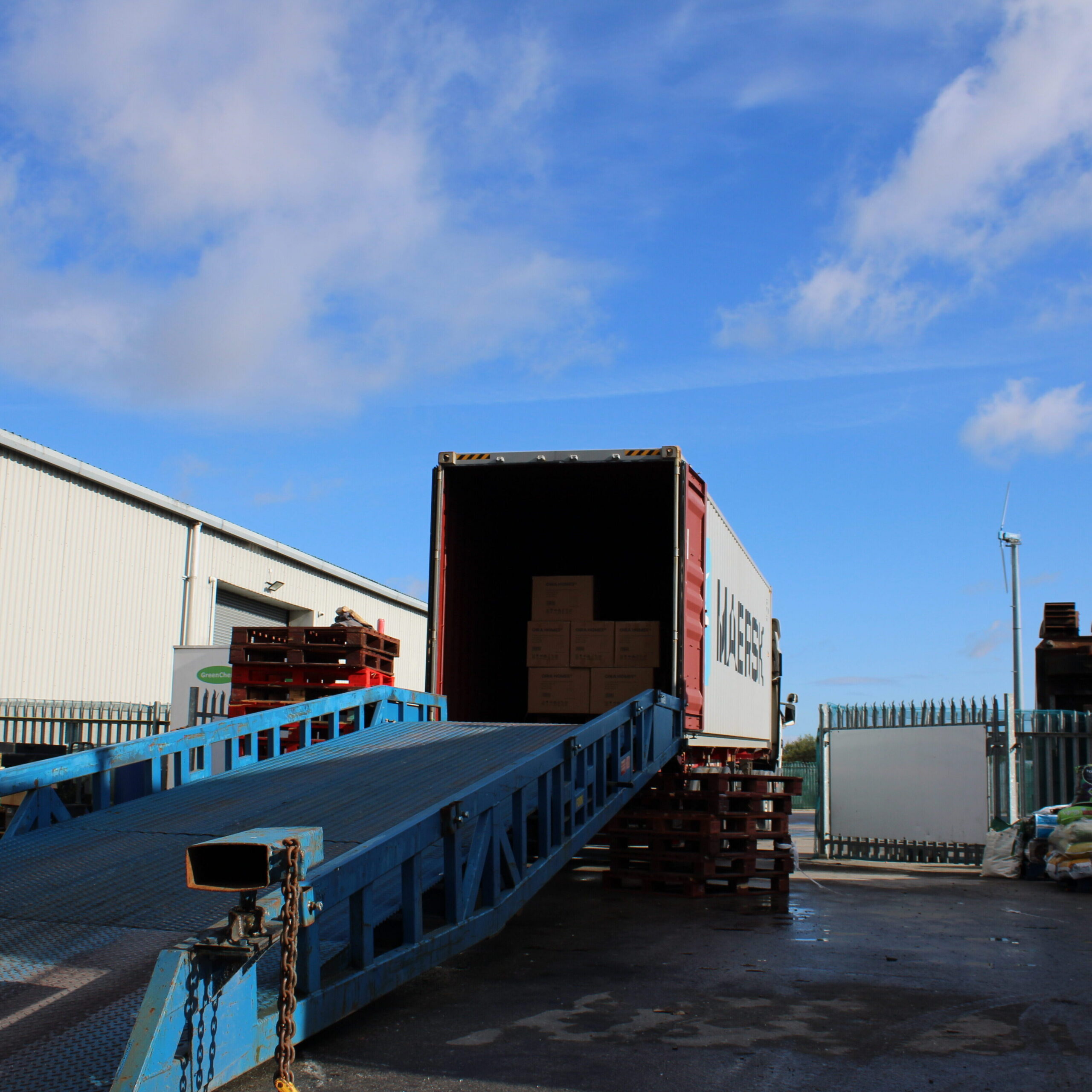 Outdoor loading dock and ramp connected to a shipping container at Ayla Group's UK freight and logistics facility