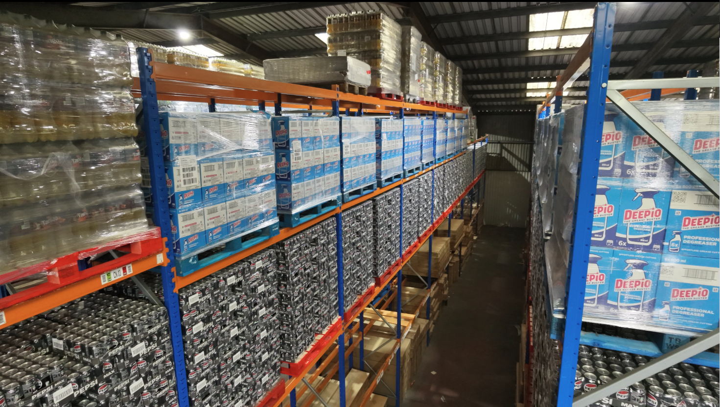 Long aisle of high-bay storage racking fully loaded with inventory boxes at Ayla Group's UK fulfilment warehouse